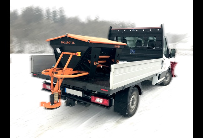 Small drop-side truck with a Lehner winter service salt spreader installed in the load bed.